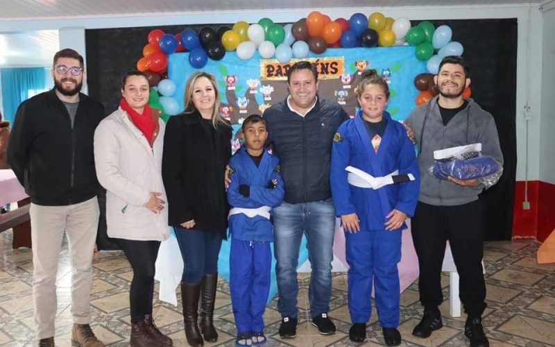 PREFEITO VITÓRIO E A SECRETÁRIA DE ASSISTÊNCIA SOCIAL CIRENE ANTUNES DA ROSA ENTREGAM OS UNIFORMES DA OFICINA DE JIU JIT